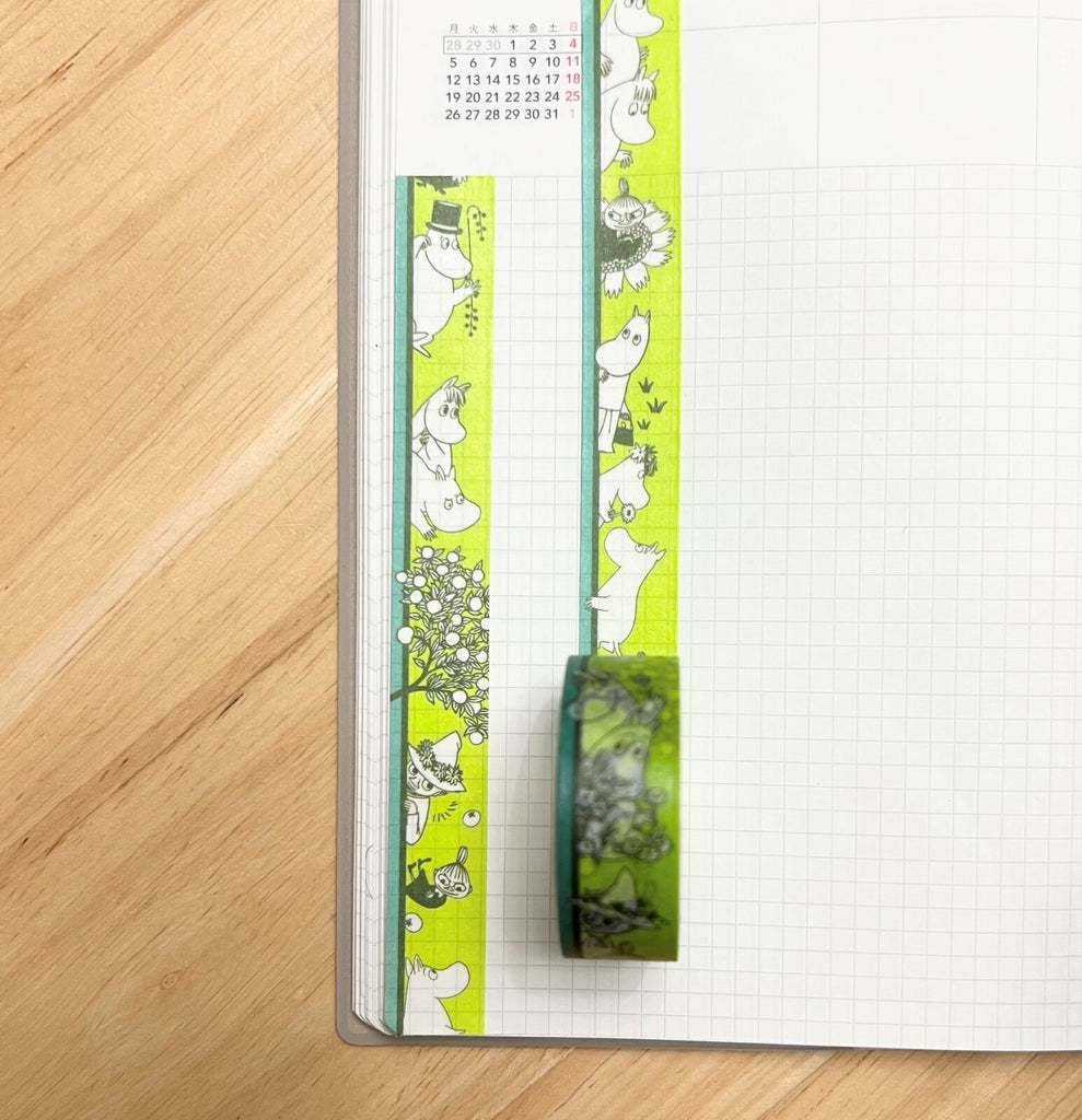 Moomin Border Green Masking Tape applied along the edge of a notebook page, adding a vibrant pop of green and character.
