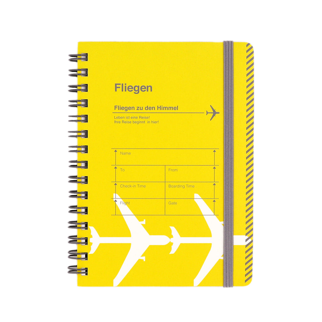 A6 yellow ring notebook with an airplane travel motif on the cover.
