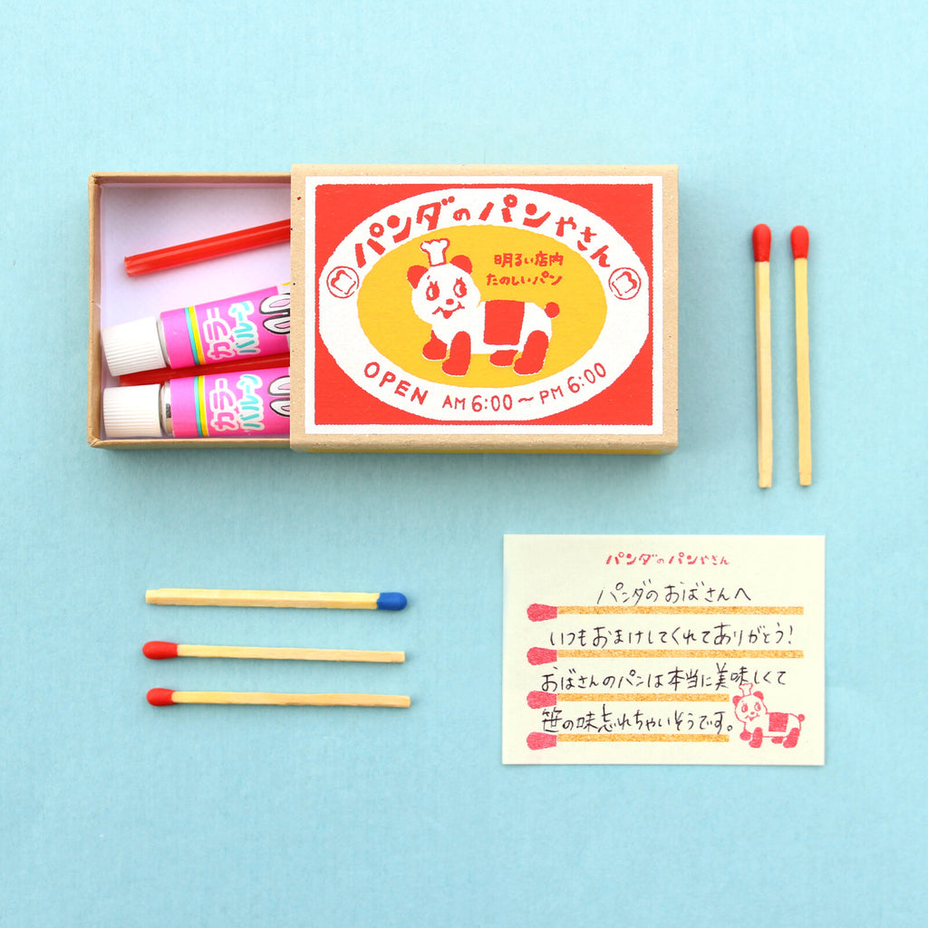 Panda’s Bakery memo box with vibrant red and yellow design and matchstick memo sheets
