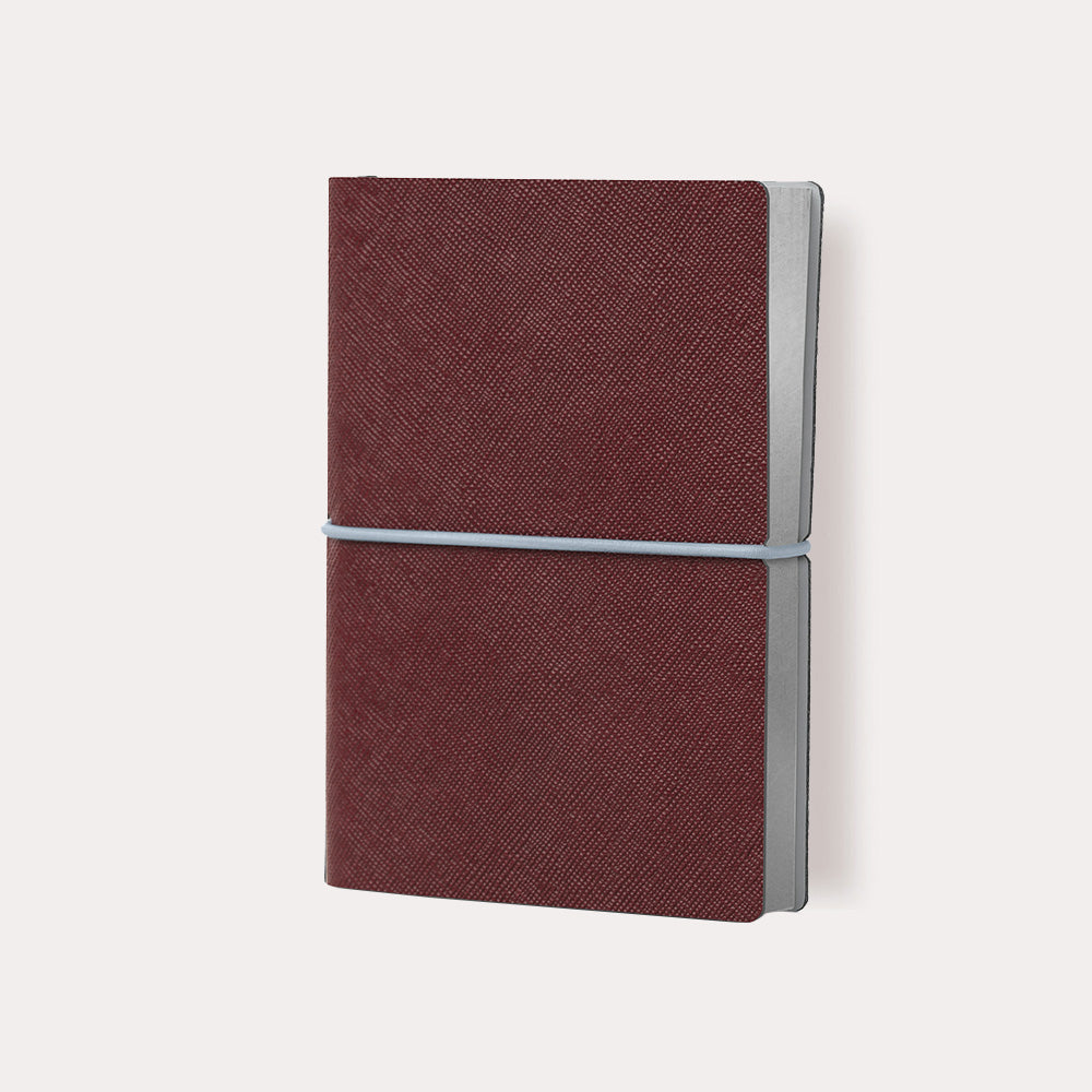 Ciak Plus Notebook in Red, neatly closed with the horizontal elastic strap.
