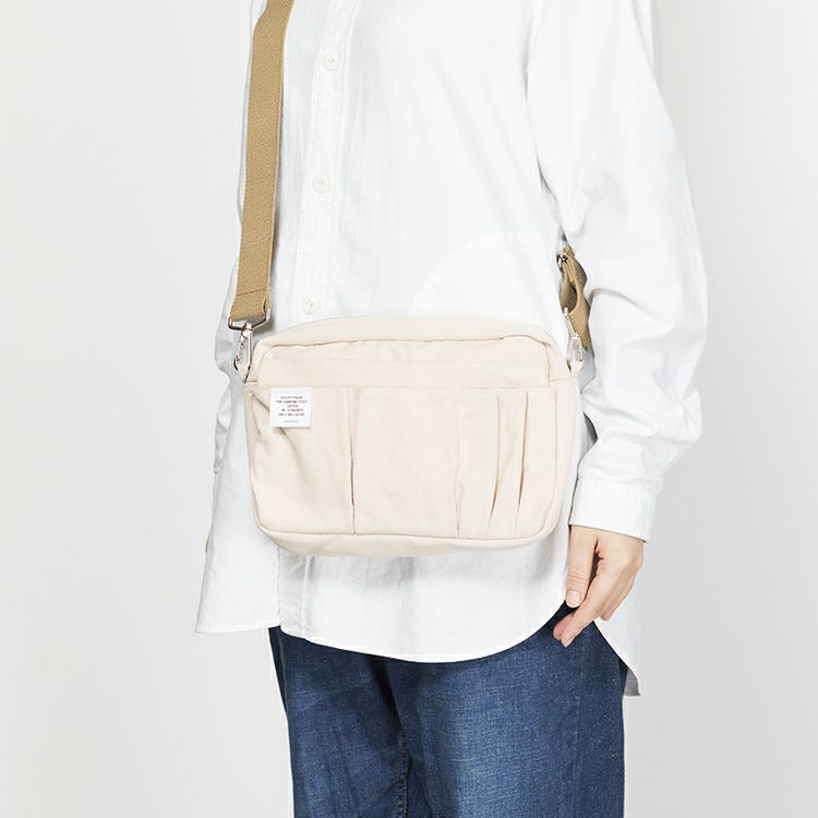 Delfonics Inner Carrying Utility Pouch M worn with a detachable strap as a crossbody bag.
